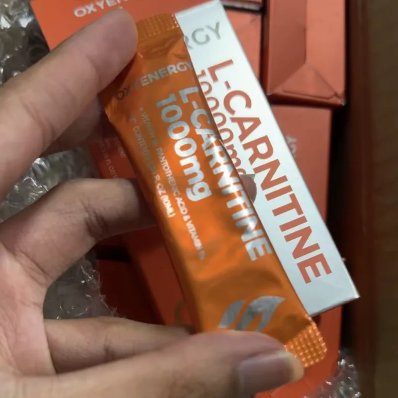 Buyer's photo — an L-Carnitine 1000mg sachet held in the hand in front of the other boxes